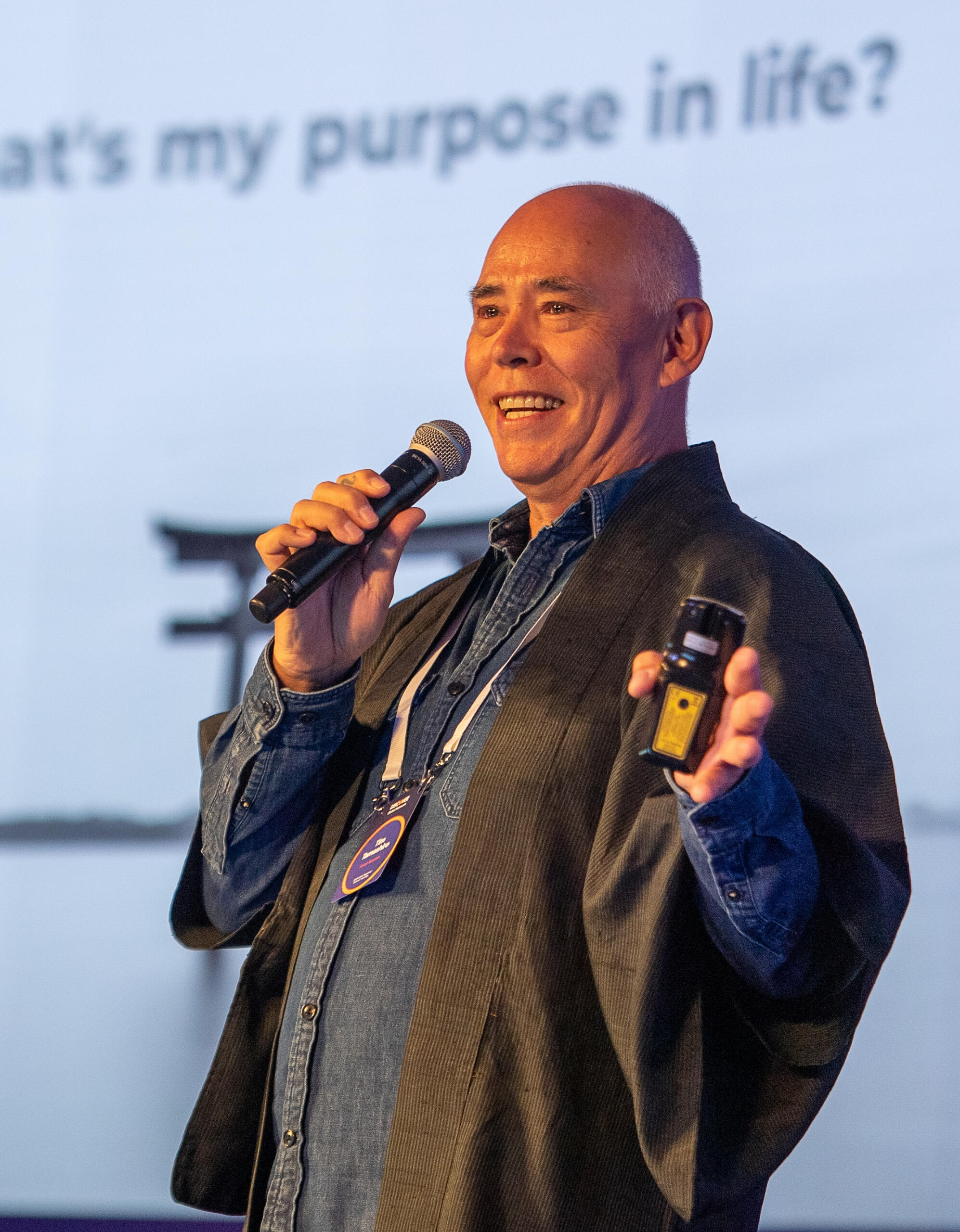 Tim Tamashiro speaking on stage in Tokyo at a Discover Card event in 2025, delivering a keynote presentation.